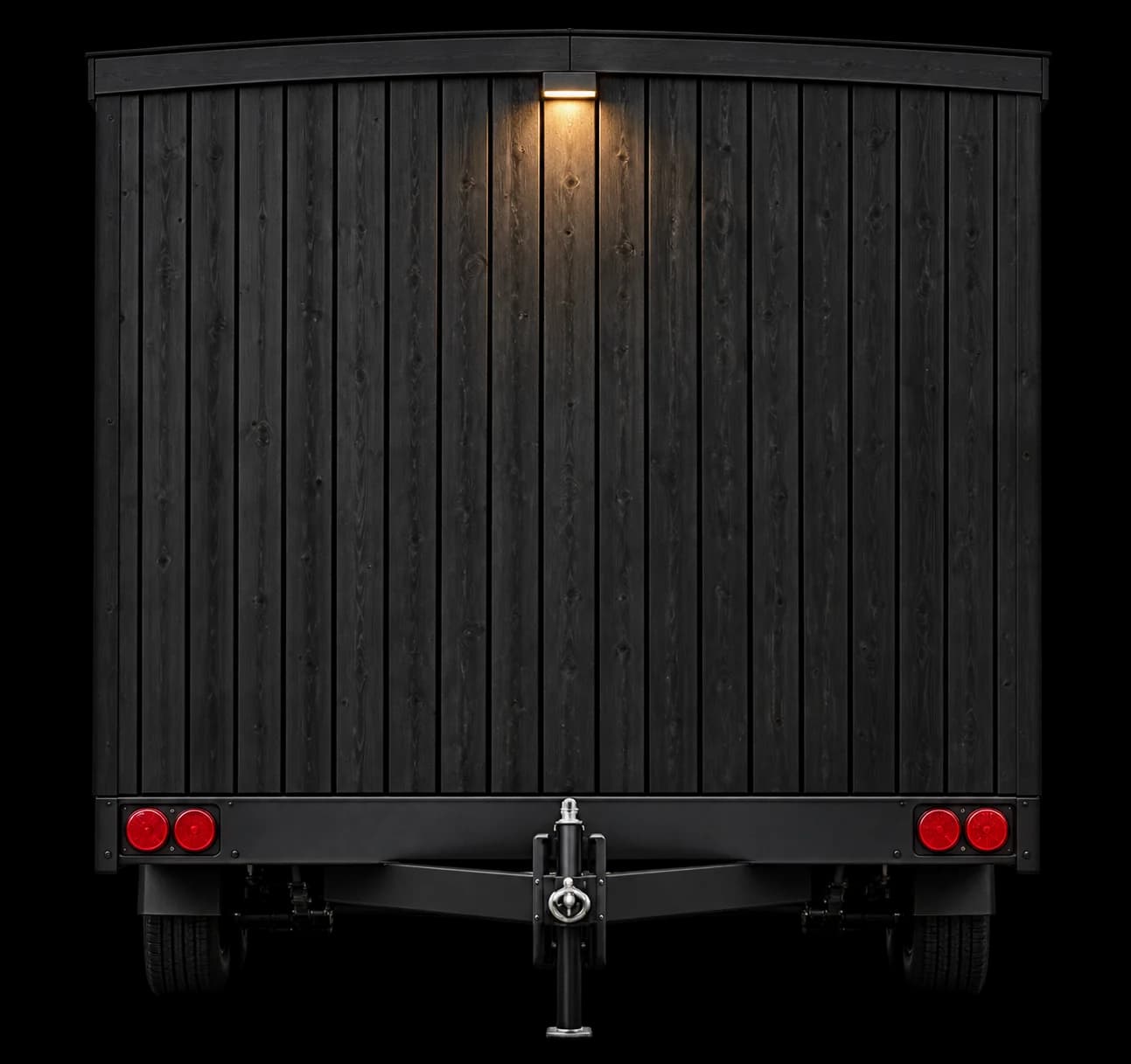 Rear view of the Mobile Wellness Unit sauna trailer, showing black vertical timber cladding and the trailer lights
